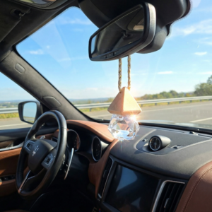 KQScents Care diffuser hanging from the rear view mirror in the inside of a car